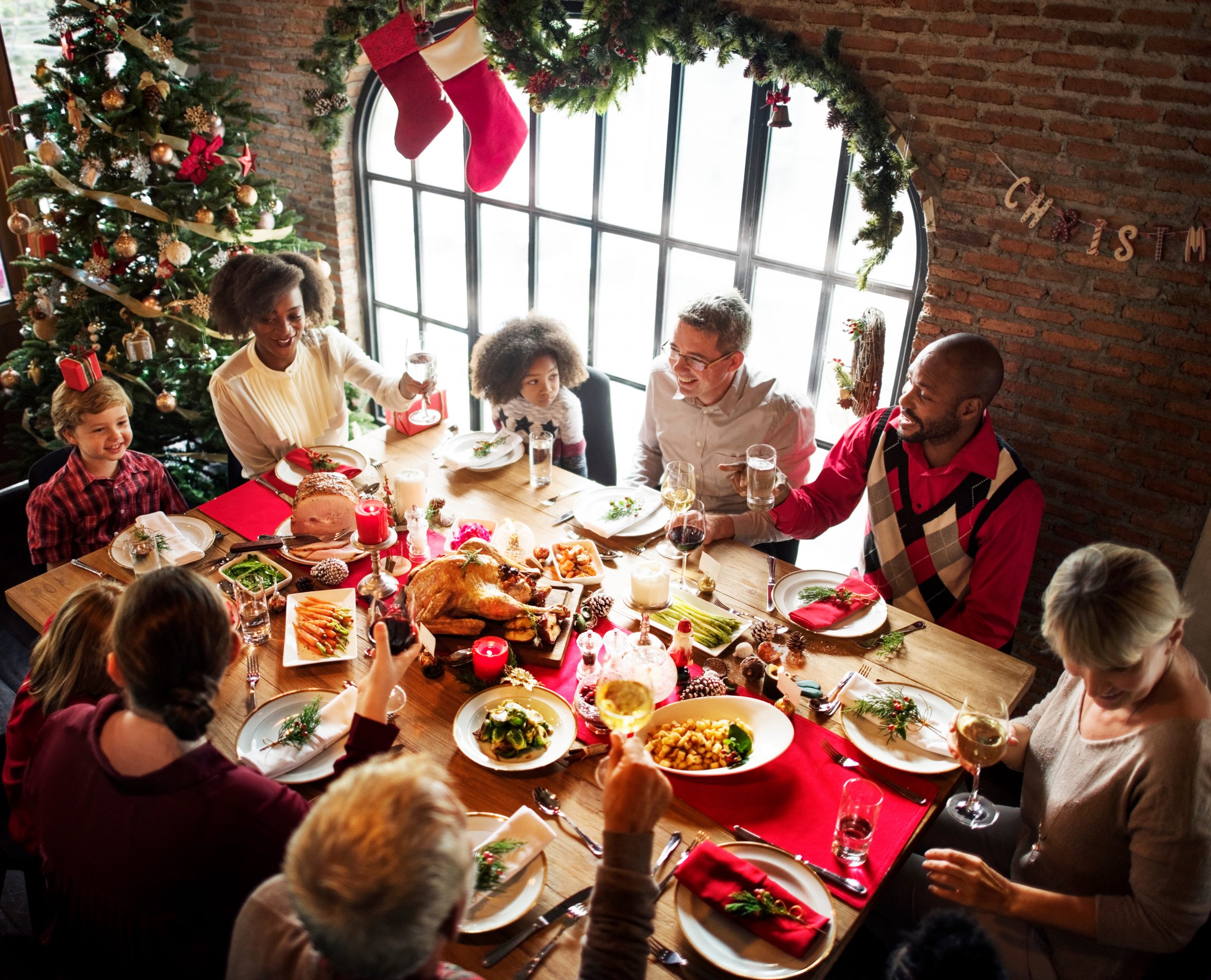 Multi-ethnic family and friends around dining room table at Christmas time
